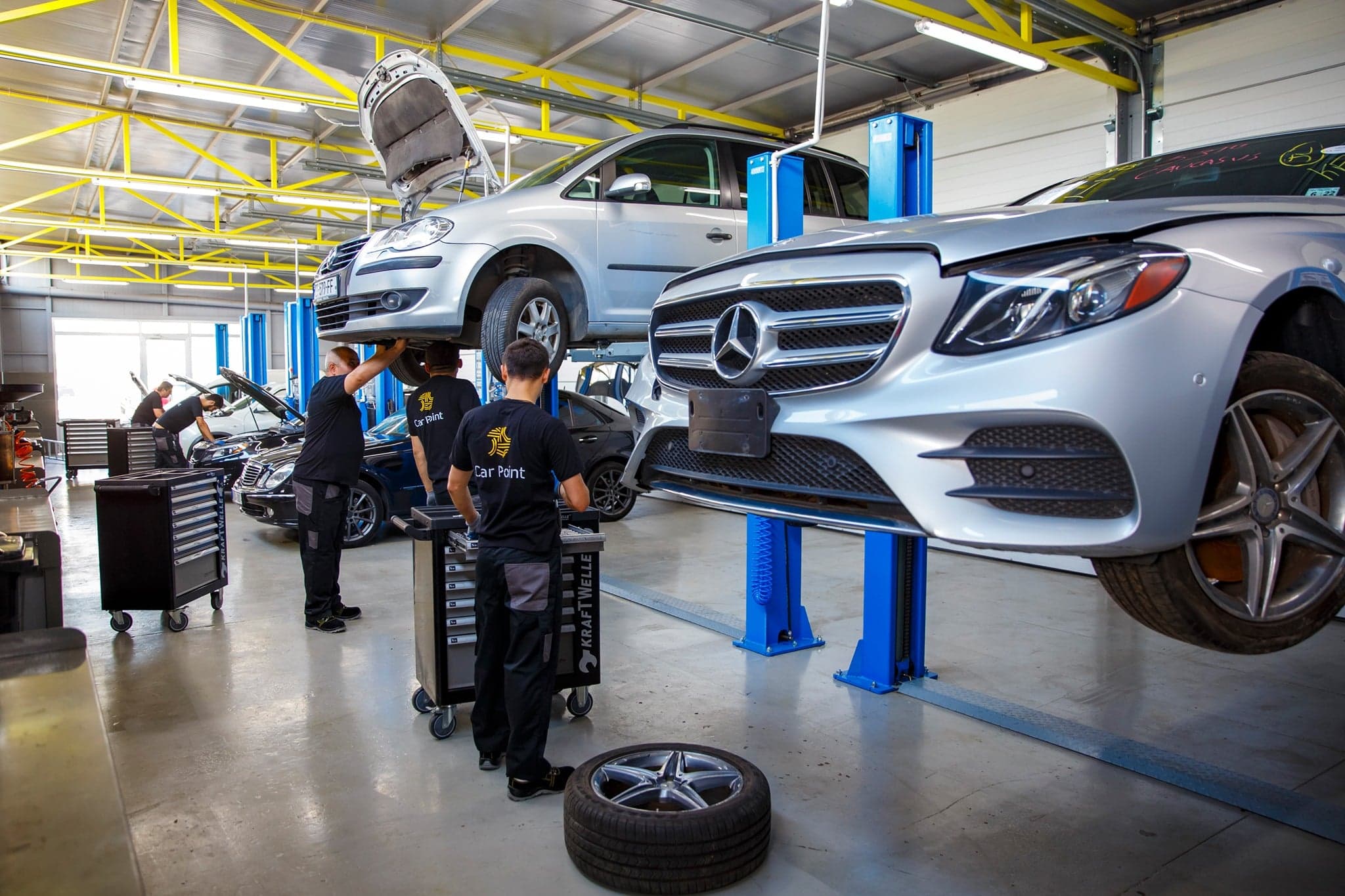 CarPoint mechanics inspecting a Mercedes-Benz on a vehicle lift